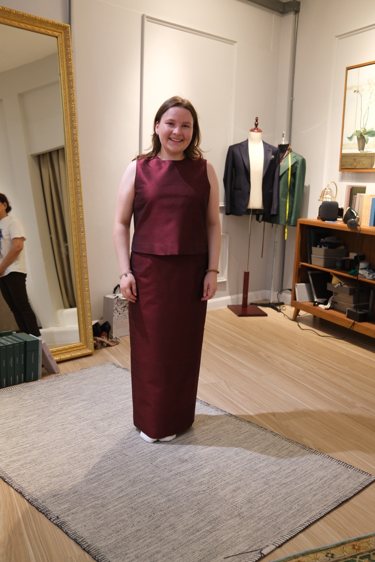 Customer in a custom maroon Thai silk dress at the LALEDA atelier