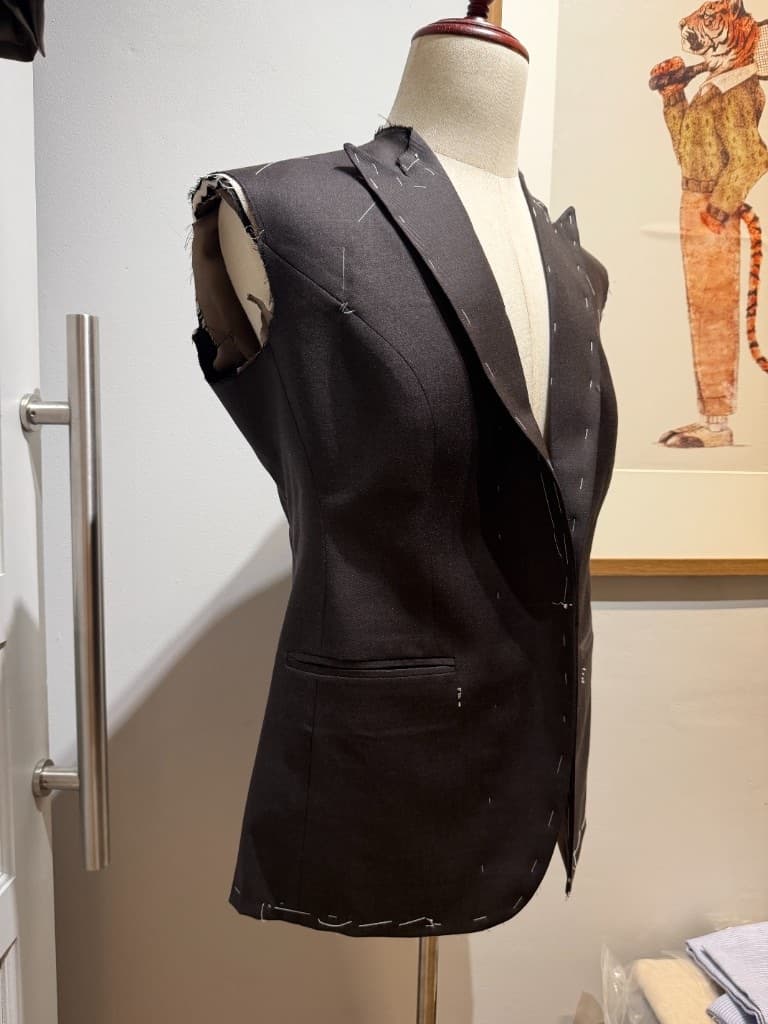 Women's bespoke suit jacket in basted construction on a mannequin